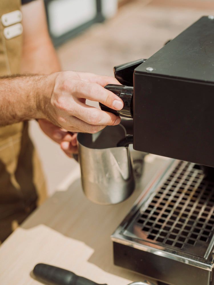 Barista locking in a portafilter at the Krema coffee cart