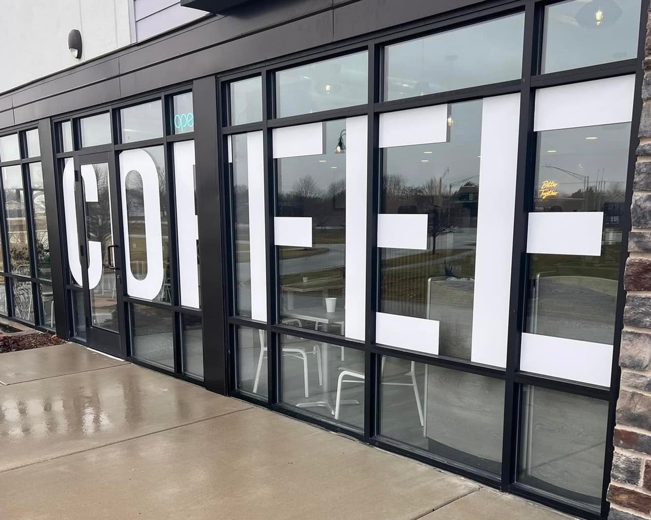 Krema Coffee Roasters storefront with COFFEE in the windows, North Aurora