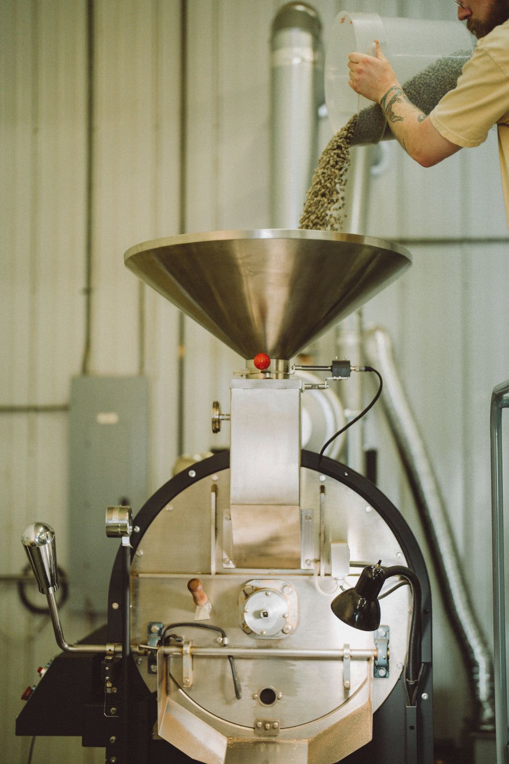 Green coffee beans poured into the Krema roaster